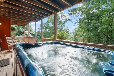 Covered deck hot tub overlooking the forest