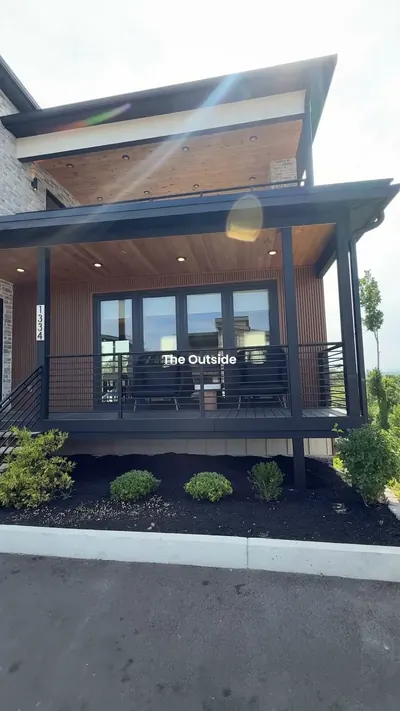 Modern dark two-story cabin exterior with balcony