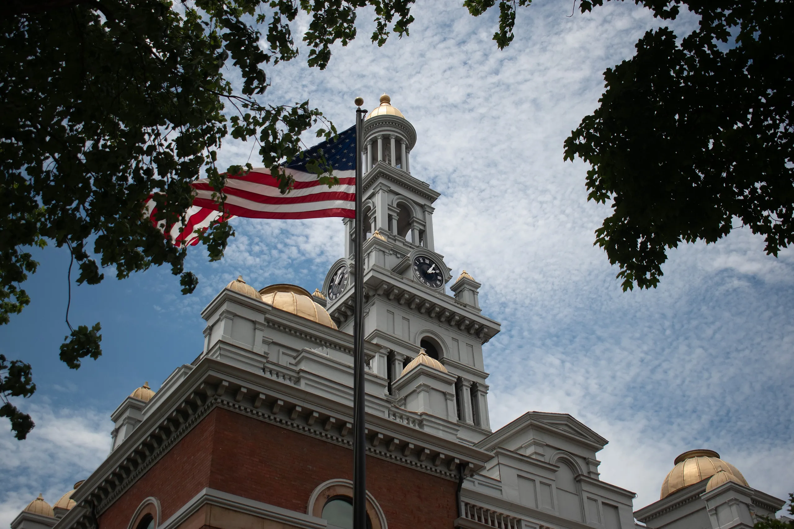 American flag flying beside the clock tower of the historic Sevier County Courthouse in Sevierville, Tennessee